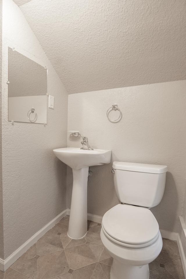 3919 Dupont Ave N, Minneapolis, MN 55412 - half bath featuring lofted ceiling, a textured ceiling, and tile patterned floors