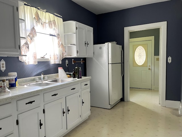1157 6th Ave S, Windom, MN 56101 - kitchen with freestanding refrigerator, light floors, white cabinets, open shelves, and light countertops