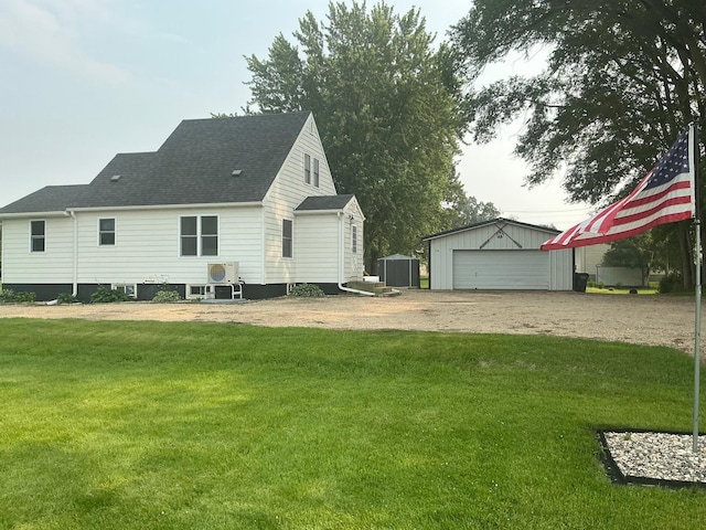705 State Highway 28 W, Glenwood, MN 56334 - back of house with a detached garage, a yard, a shingled roof, and a storage unit