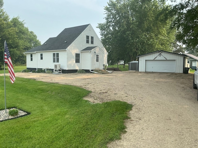 705 State Highway 28 W, Glenwood, MN 56334 - rear view of house featuring an outdoor structure, a yard, a detached garage, driveway, and a shingled roof