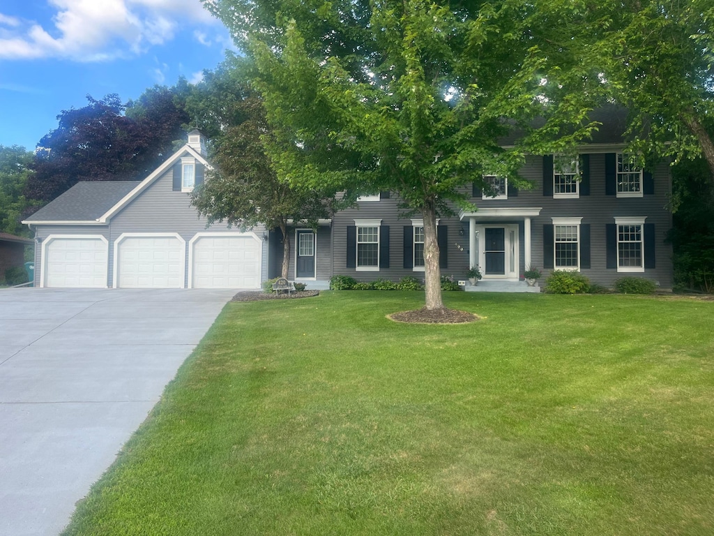 420 127th Ln NW, Coon Rapids, MN 55448 - colonial home with a garage, driveway, a front yard, and a chimney