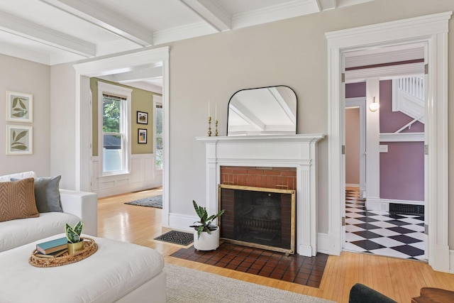 2432 Pleasant Ave, Minneapolis, MN 55404 - living room with beamed ceiling, wood finished floors, a brick fireplace, and wainscoting