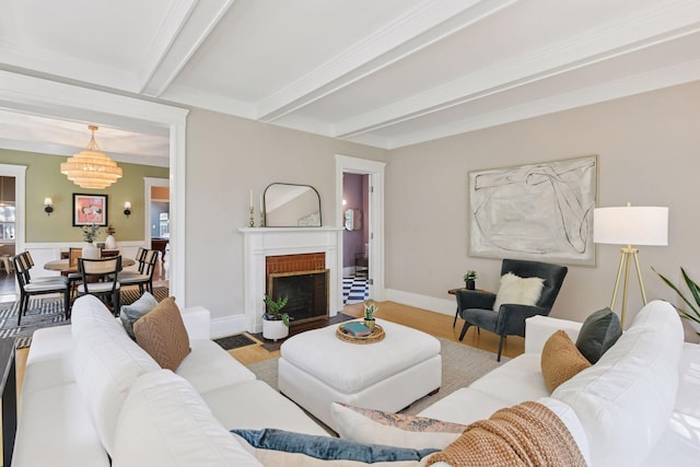 2432 Pleasant Ave, Minneapolis, MN 55404 - living room with wood finished floors, beam ceiling, a brick fireplace, ornamental molding, and a chandelier