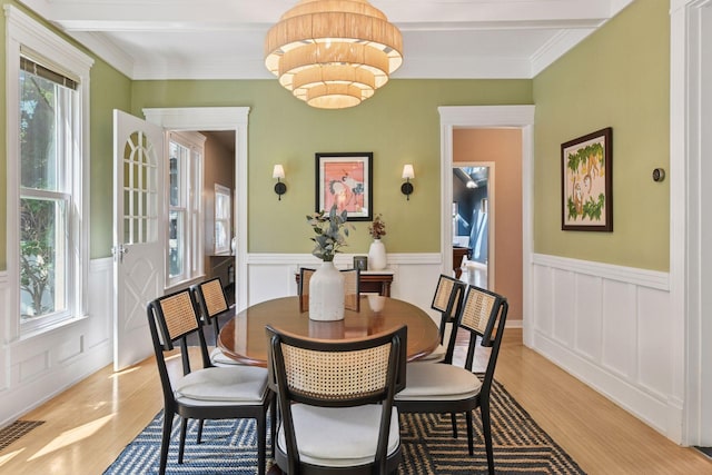 2432 Pleasant Ave, Minneapolis, MN 55404 - dining space with light wood-type flooring, wainscoting, a decorative wall, ornamental molding, and a chandelier