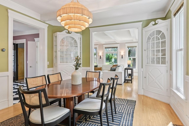 2432 Pleasant Ave, Minneapolis, MN 55404 - dining room featuring light wood-style flooring, beamed ceiling, a wainscoted wall, ornamental molding, and a decorative wall
