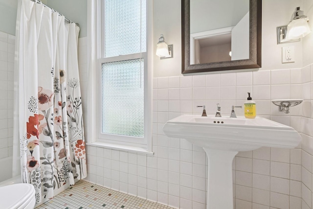 2432 Pleasant Ave, Minneapolis, MN 55404 - bathroom featuring tile walls, tile patterned flooring, shower / bath combination with curtain, and a wainscoted wall