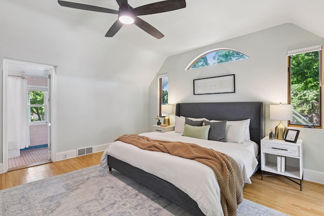 2432 Pleasant Ave, Minneapolis, MN 55404 - bedroom featuring lofted ceiling, multiple windows, wood finished floors, a ceiling fan, and ensuite bath