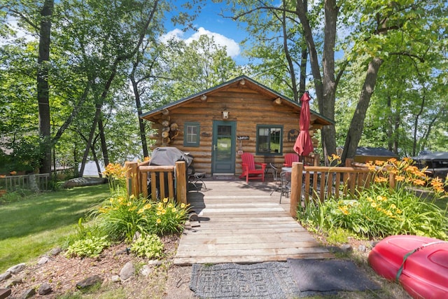 29351 410th Pl, Farm Island Twp, MN 56431 - view of front facade featuring a wooden deck, log siding, and a front yard