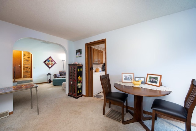 18726 Juneberry Rd, Mankato, MN 56001 - dining space featuring arched walkways, light carpet, and washer / clothes dryer
