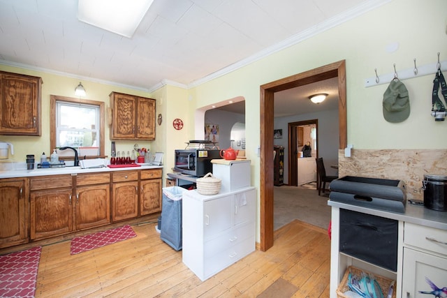 18726 Juneberry Rd, Mankato, MN 56001 - kitchen featuring stainless steel microwave, light countertops, brown cabinetry, light wood-type flooring, and crown molding