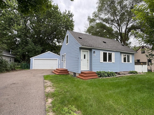 44 Center Rd, Circle Pines, MN 55014 - view of front of house with an outbuilding, a garage, a shingled roof, and a front lawn