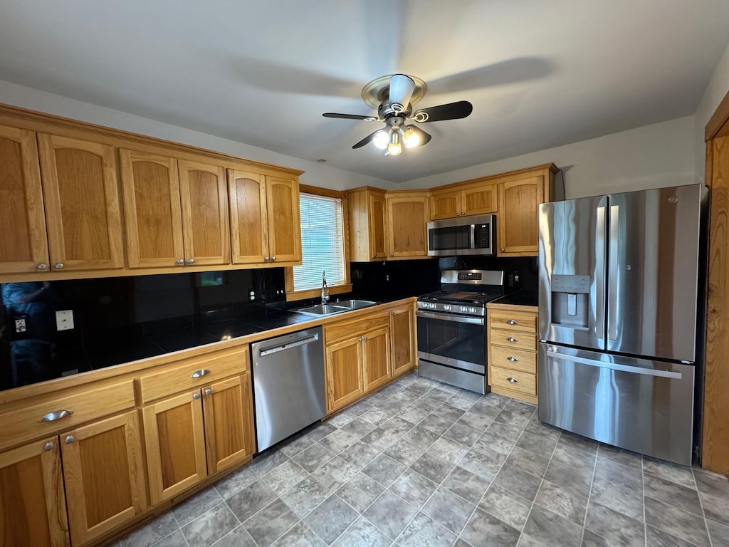 44 Center Rd, Circle Pines, MN 55014 - kitchen featuring stainless steel appliances, tile countertops, a ceiling fan, stone finish flooring, and brown cabinets
