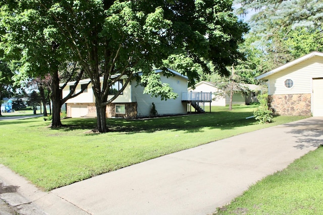 2001 25th St SW, Willmar, MN 56201 - view of side of property with stone siding, a lawn, a deck, and concrete driveway