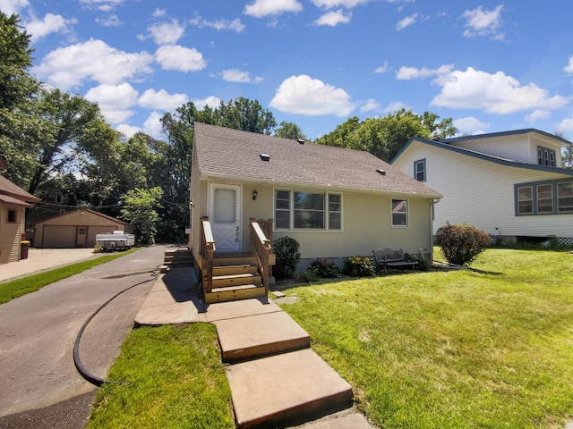 206 Winona St W, West Saint Paul, MN 55118 - view of front facade featuring entry steps, a front lawn, an outbuilding, stucco siding, and roof with shingles