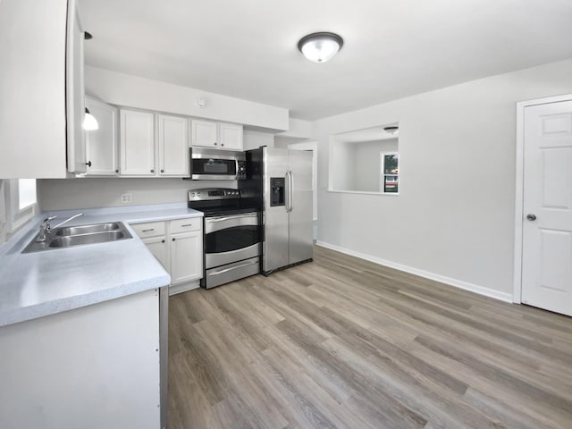 206 Winona St W, West Saint Paul, MN 55118 - kitchen featuring stainless steel appliances, light countertops, white cabinets, and light wood-style flooring