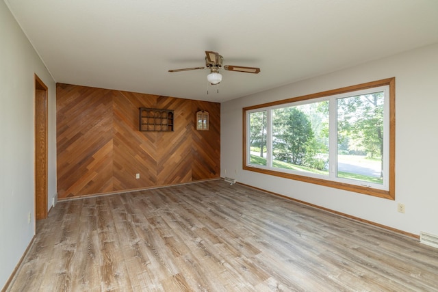 110 Hamilton Dr, River Falls, WI 54022 - unfurnished room with a ceiling fan, wood walls, and light wood finished floors