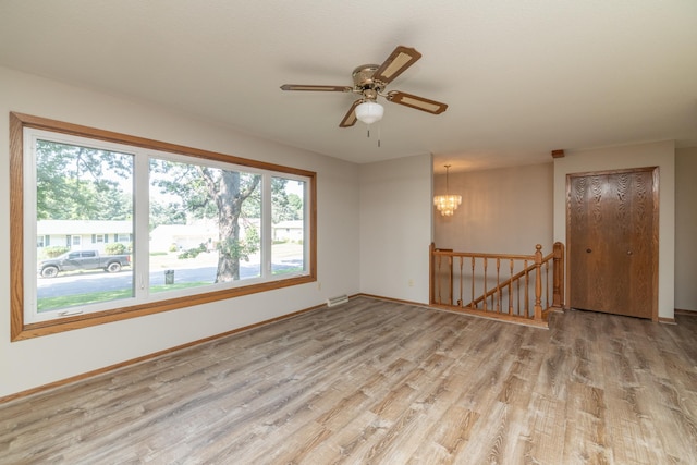110 Hamilton Dr, River Falls, WI 54022 - unfurnished room featuring light wood-style flooring, a chandelier, and ceiling fan