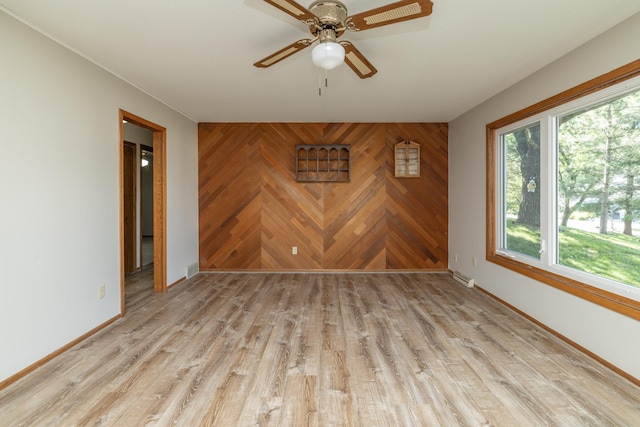 110 Hamilton Dr, River Falls, WI 54022 - unfurnished room featuring ceiling fan, light wood-style floors, and wood walls