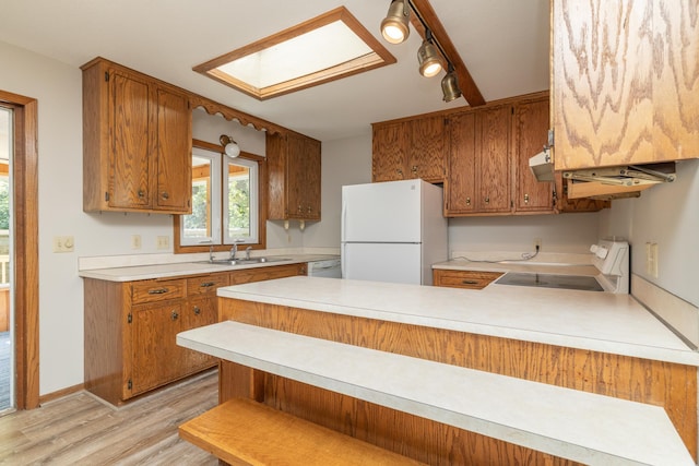 110 Hamilton Dr, River Falls, WI 54022 - kitchen featuring freestanding refrigerator, stove, light countertops, a peninsula, and light wood-type flooring