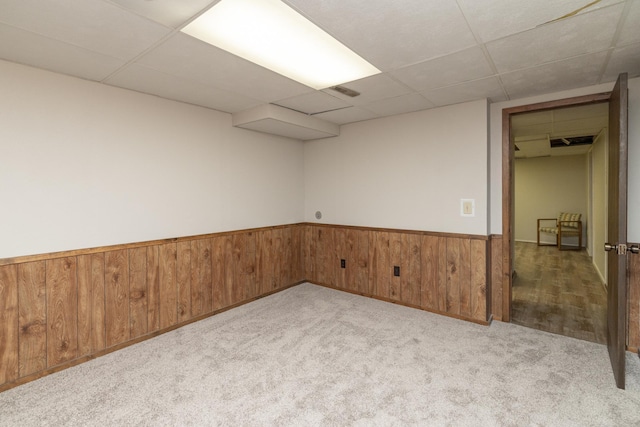 110 Hamilton Dr, River Falls, WI 54022 - carpeted empty room featuring a drop ceiling, a wainscoted wall, and wood walls