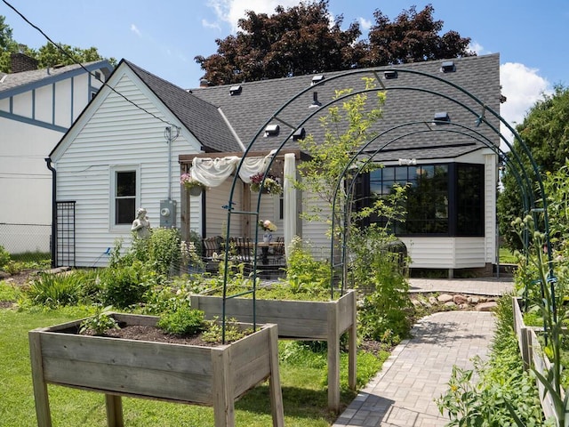 5529 1st Ave S, Minneapolis, MN 55419 - back of house featuring a garden, roof with shingles, board and batten siding, and a sunroom