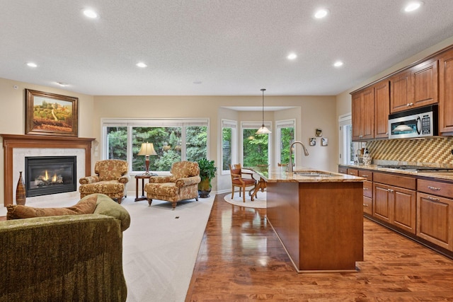 11444 Clarion Way, Minnetonka, MN 55343 - kitchen with appliances with stainless steel finishes, open floor plan, recessed lighting, light stone countertops, and a premium fireplace