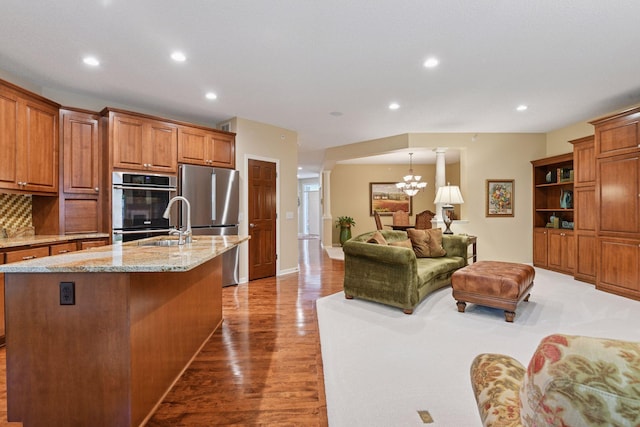 11444 Clarion Way, Minnetonka, MN 55343 - kitchen with appliances with stainless steel finishes, recessed lighting, wood finished floors, light stone counters, and a chandelier