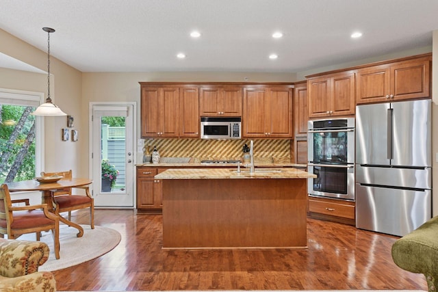11444 Clarion Way, Minnetonka, MN 55343 - kitchen with appliances with stainless steel finishes, brown cabinetry, light stone countertops, decorative backsplash, and recessed lighting