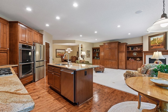11444 Clarion Way, Minnetonka, MN 55343 - kitchen featuring stainless steel appliances, open floor plan, light wood-style floors, a fireplace, and recessed lighting