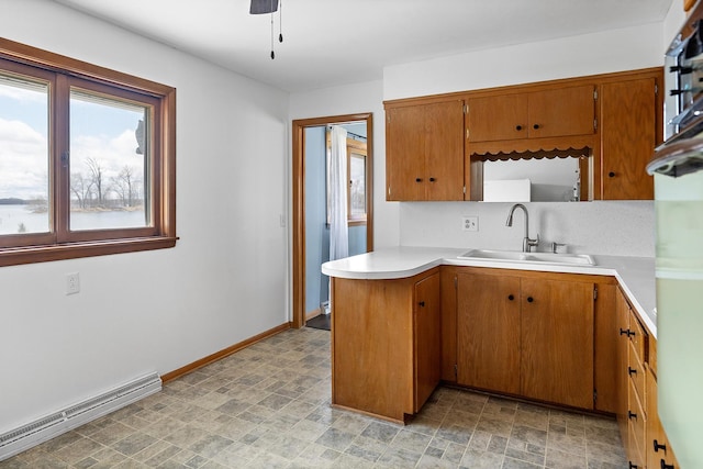 520 Park Island Rd Unit 2, Center City, MN 55012 - kitchen featuring a baseboard radiator, brown cabinetry, light countertops, a peninsula, and ceiling fan