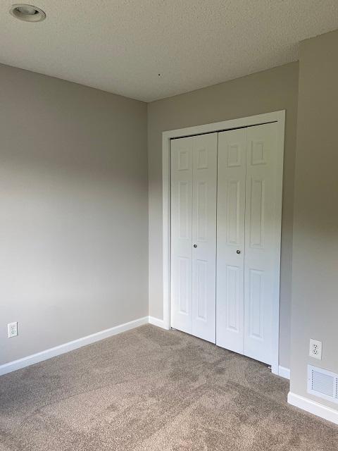 1340 119th Ln NW, Coon Rapids, MN 55448 - unfurnished bedroom with carpet floors and a closet