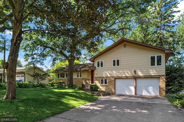 26 Golden Lake Rd, Circle Pines, MN 55014 - split level home with an attached garage, stone siding, asphalt driveway, and a front yard