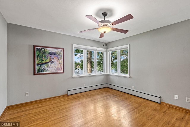26 Golden Lake Rd, Circle Pines, MN 55014 - spare room featuring wood finished floors, baseboard heating, and a ceiling fan