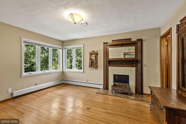 26 Golden Lake Rd, Circle Pines, MN 55014 - unfurnished living room featuring a baseboard heating unit, wood finished floors, and a tile fireplace