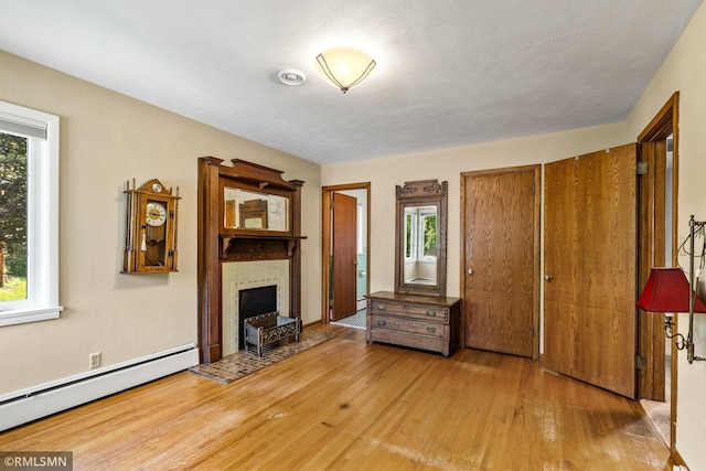 26 Golden Lake Rd, Circle Pines, MN 55014 - living room with a baseboard radiator, wood finished floors, and a tile fireplace