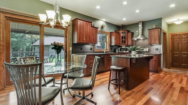 3946 Woodcrest Ct, Eau Claire, WI 54701 - kitchen with wall chimney exhaust hood, light wood-style flooring, decorative backsplash, a kitchen island, and recessed lighting