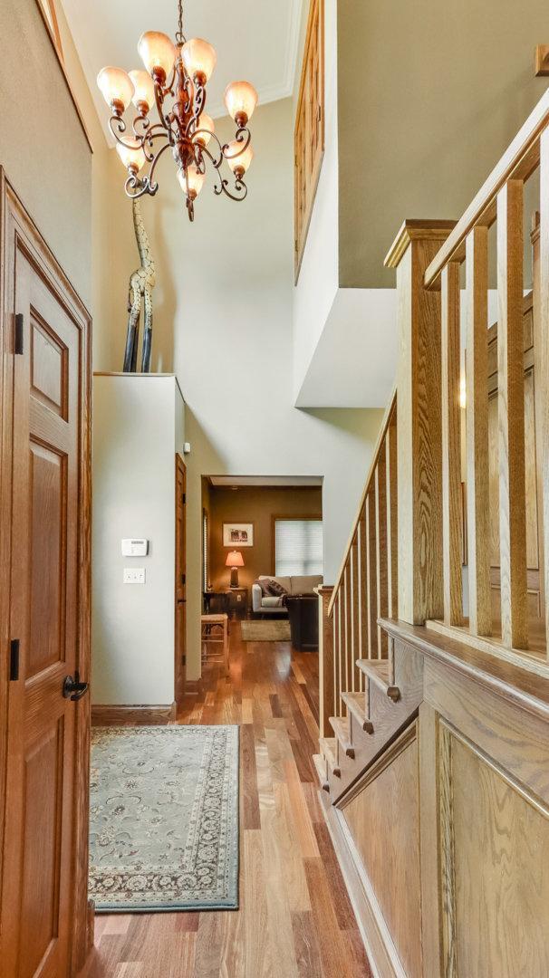 3946 Woodcrest Ct, Eau Claire, WI 54701 - foyer entrance featuring a chandelier, wood finished floors, stairs, and a high ceiling