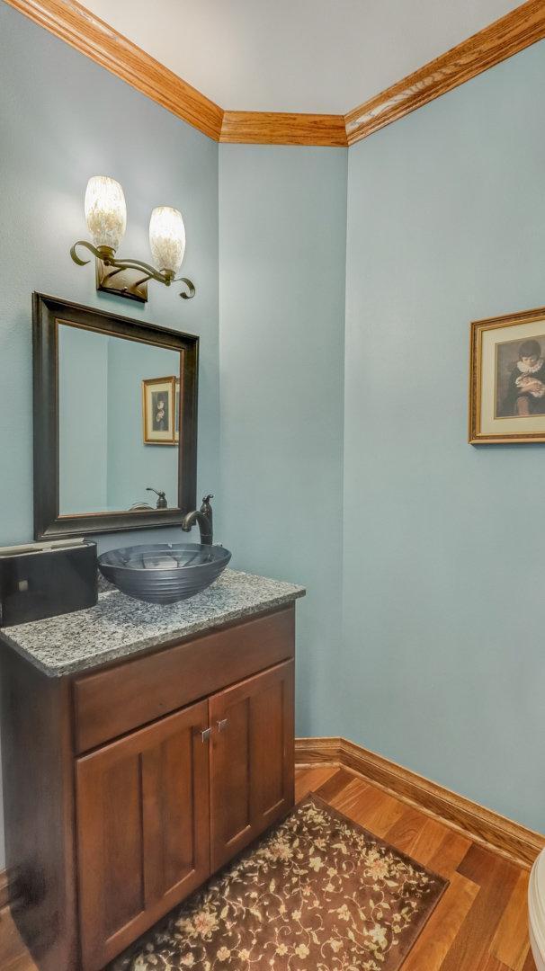 3946 Woodcrest Ct, Eau Claire, WI 54701 - half bathroom featuring crown molding, vanity, and wood finished floors