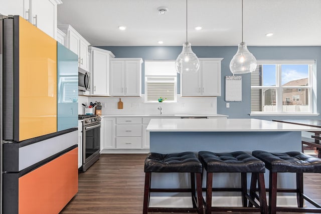11374 81st St NE, Otsego, MN 55330 - kitchen with stainless steel appliances, backsplash, white cabinets, a breakfast bar, and recessed lighting