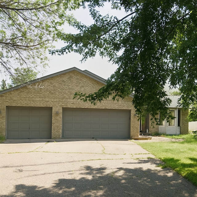 1199 Sunrise Dr, Woodbury, MN 55125 - view of front facade with brick siding, driveway, a garage, and a front lawn
