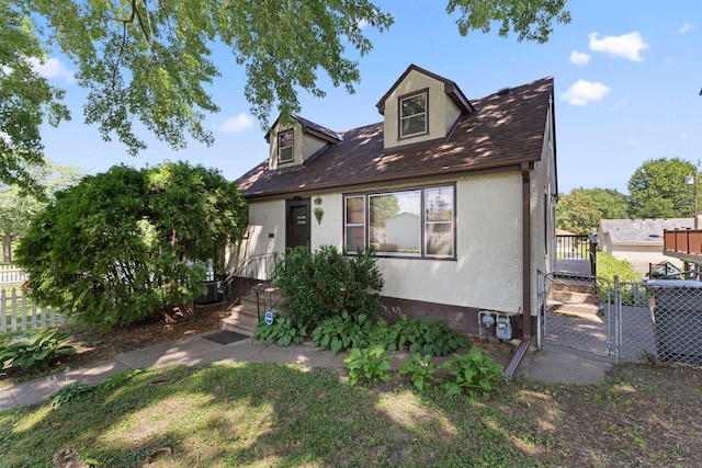 4251 Quincy St NE, Columbia Heights, MN 55421 - cape cod-style house with a gate and stucco siding