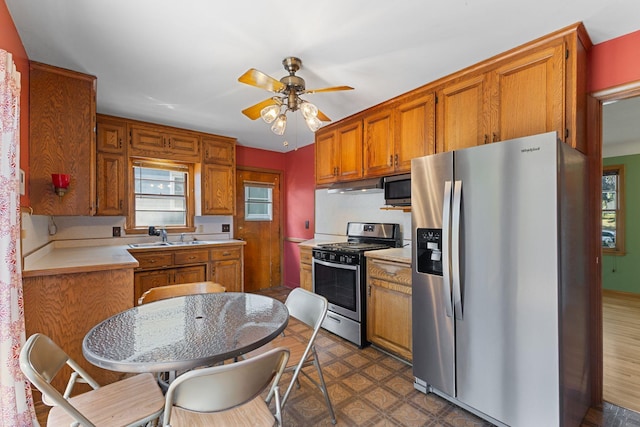 4251 Quincy St NE, Columbia Heights, MN 55421 - kitchen with stainless steel appliances, light countertops, plenty of natural light, and brown cabinets