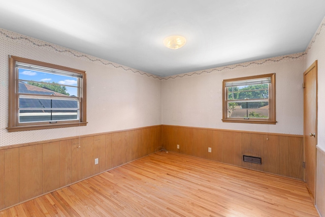 4251 Quincy St NE, Columbia Heights, MN 55421 - empty room featuring wood finished floors, plenty of natural light, wainscoting, and wood walls