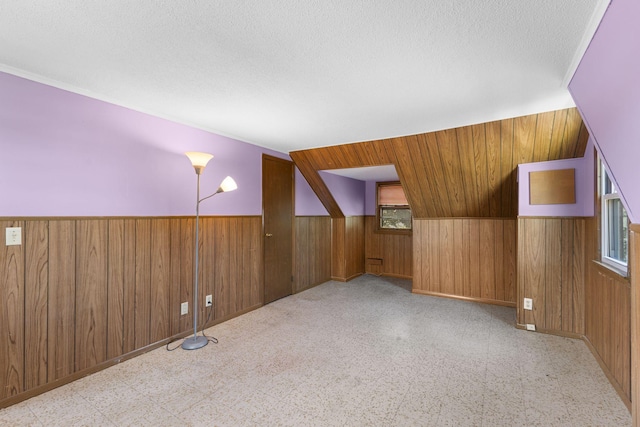 4251 Quincy St NE, Columbia Heights, MN 55421 - additional living space with wooden walls, wainscoting, a textured ceiling, and tile patterned floors