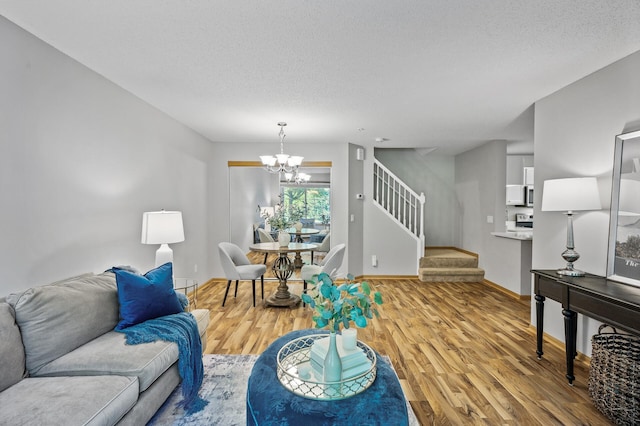 8484 Minuteman Alcove, Eden Prairie, MN 55344 - living room featuring a chandelier, stairs, wood finished floors, and a textured ceiling