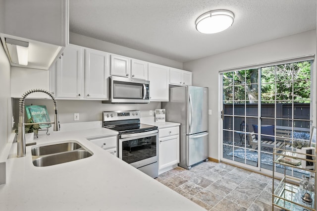 8484 Minuteman Alcove, Eden Prairie, MN 55344 - kitchen featuring appliances with stainless steel finishes, light countertops, a textured ceiling, white cabinetry, and stone finish floors