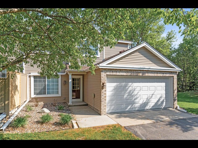 8484 Minuteman Alcove, Eden Prairie, MN 55344 - view of front of house with a garage, brick siding, and driveway
