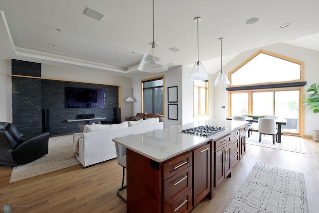 4703 Woodhaven St S, Fargo, ND 58104 - kitchen featuring stainless steel gas stovetop, light wood-type flooring, pendant lighting, a center island, and a breakfast bar
