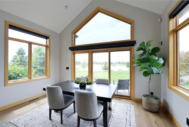 4703 Woodhaven St S, Fargo, ND 58104 - dining room featuring lofted ceiling, light wood-style flooring, and a water view