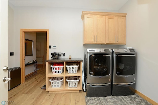 4703 Woodhaven St S, Fargo, ND 58104 - laundry area featuring cabinet space, light wood finished floors, and independent washer and dryer